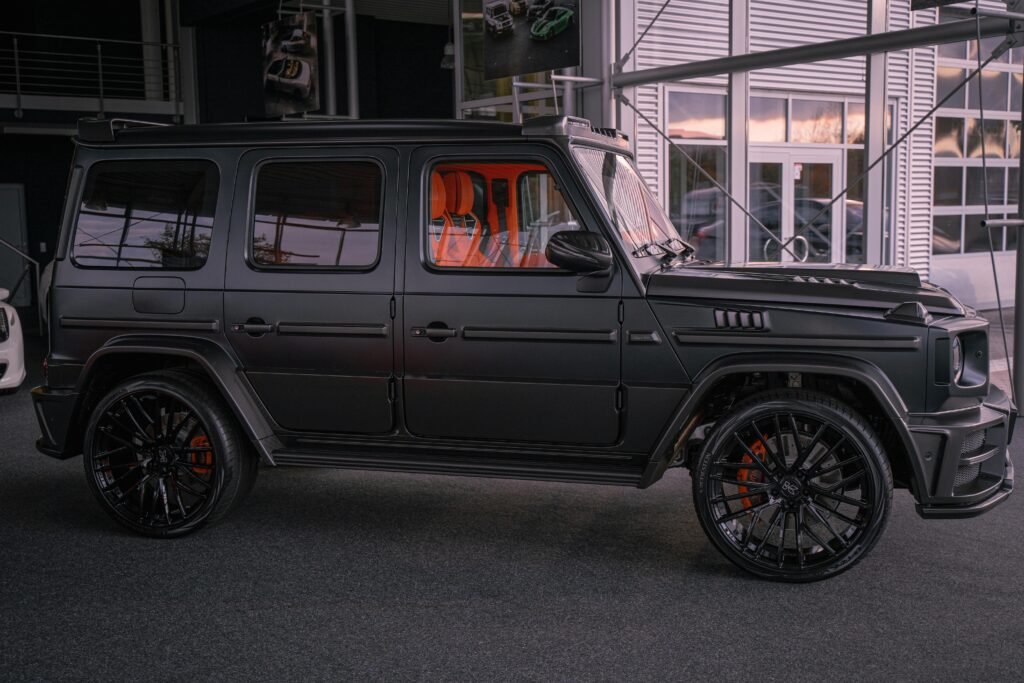 Side profile of a sleek black luxury Mercedes SUV parked in a stylish indoor garage.