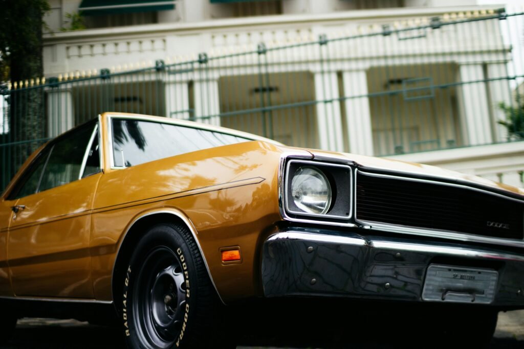 Capture of a classic 1970s Dodge car, featuring shiny chrome detailing, parked in an urban setting, highlighting vintage design.